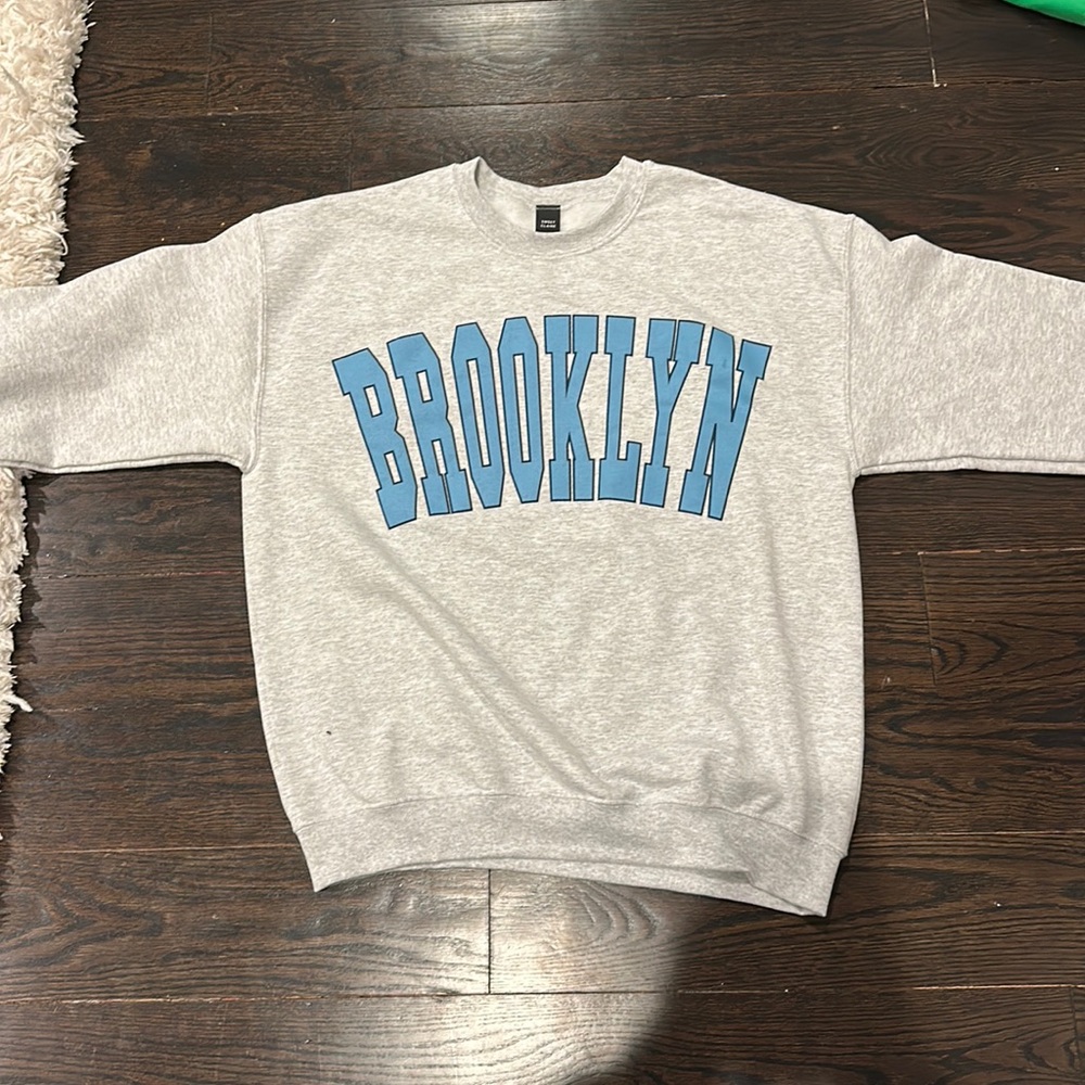 Grey crewneck in size S/M and it says Brooklyn in blue on the front